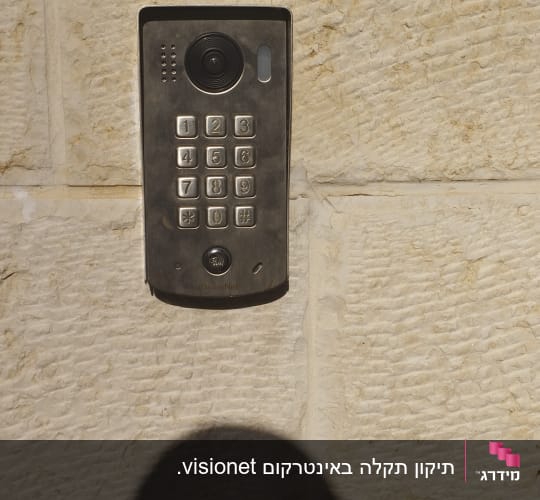 מצלמת אבטחה עם לוח מקשים על קיר אבן